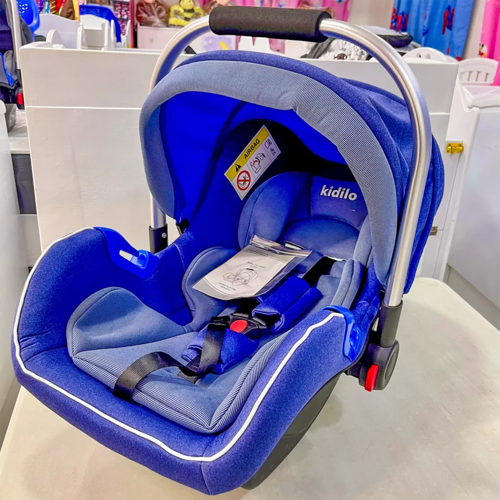 Bright blue Kidilo carrycot car seat with ergonomic padding, secure harness, and canopy, perfect for newborns, displayed at Zawadi Baby Shop.