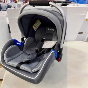 Dark grey Kidilo carrycot car seat with a modern design, padded interior, and safety features, perfect for infant travel, shown at Zawadi Baby Shop.