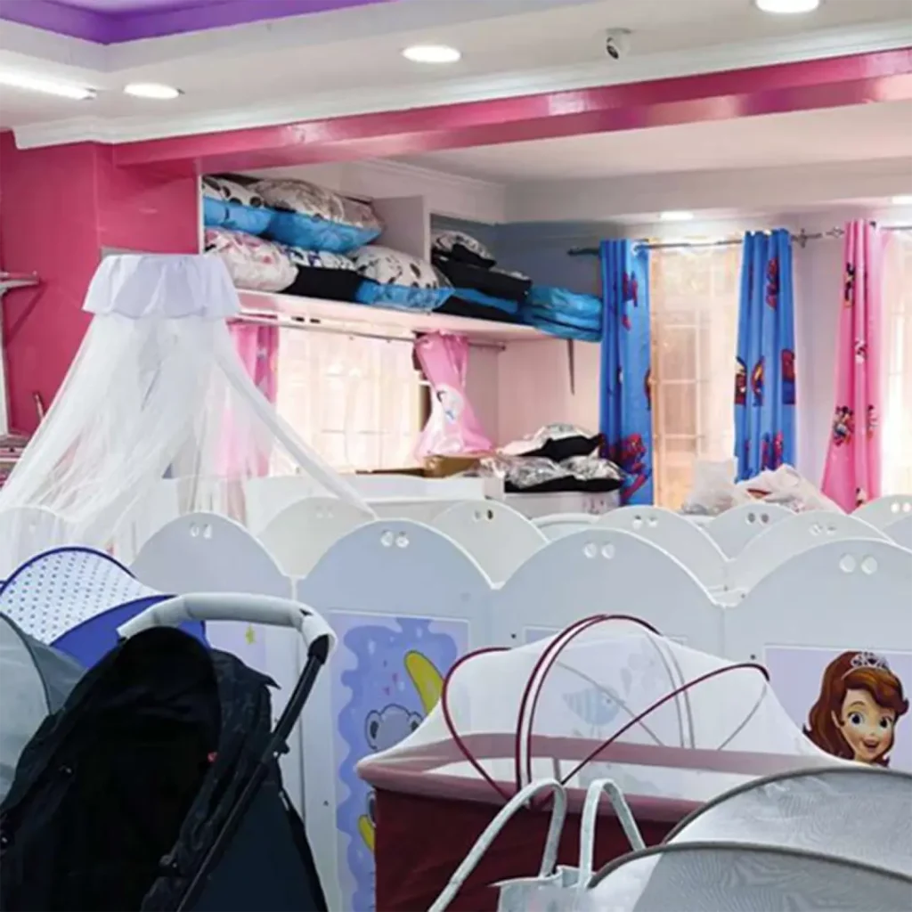 A nursery section at Zawadi Baby Shop featuring baby cribs, bassinets with mosquito nets, strollers, and neatly arranged bedding accessories.