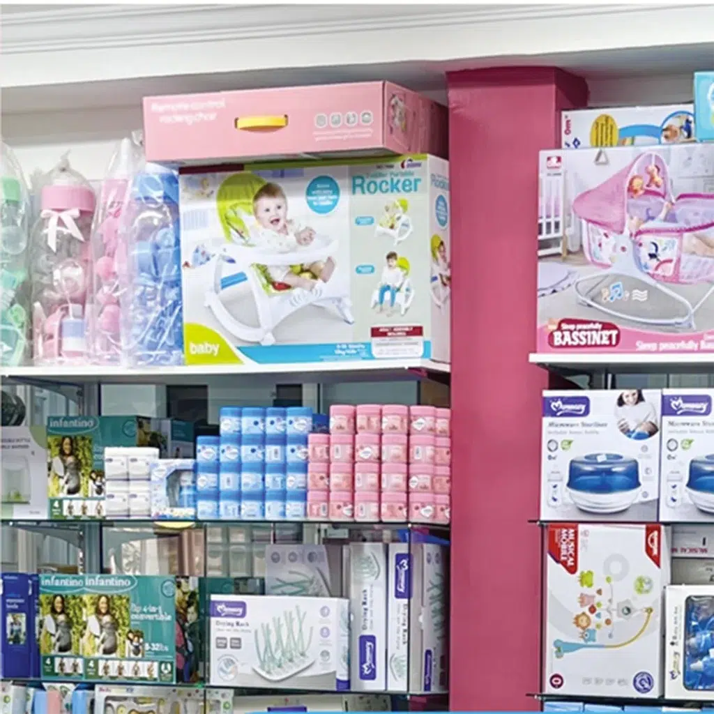 A well-stocked baby store shelf at Zawadi Baby Shop featuring baby rockers, bassinets, feeding accessories, sterilizers, diapers, and other newborn essentials.