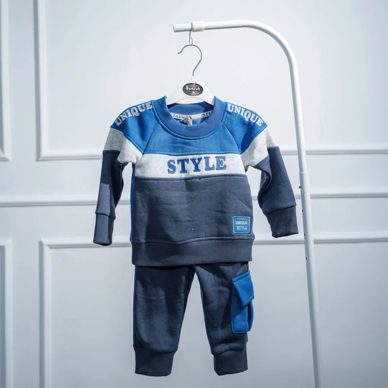Blue and grey 2-piece kids' tracksuit with 'STYLE' and 'UNIQUE' text, featuring a round-neck sweatshirt and jogger pants with side pocket, displayed on hanger