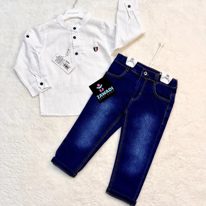 Flat lay of a boys' outfit featuring a long-sleeved dark blue shirt with a small embroidered patch and a pair of classic blue jeans, displayed on a white textured background. The set is labeled with a Zawadi Baby Shop tag.
