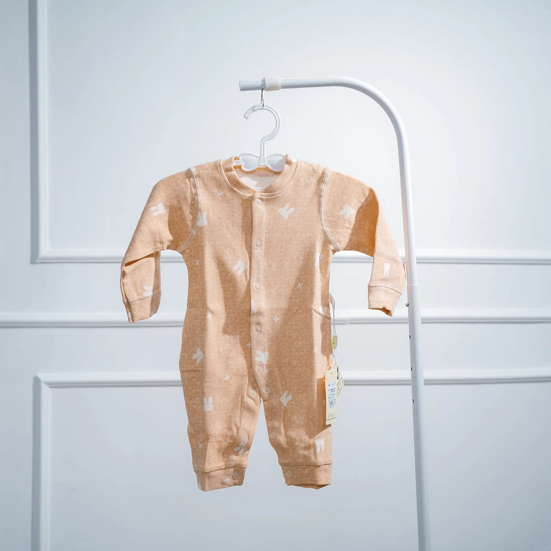 Warm Rompers 4 White Baby Romper With Patterned Sleeves And Ruffled Collar Detail, Front Snap Closures, And Decorative Bow, Displayed On A Hanger.
