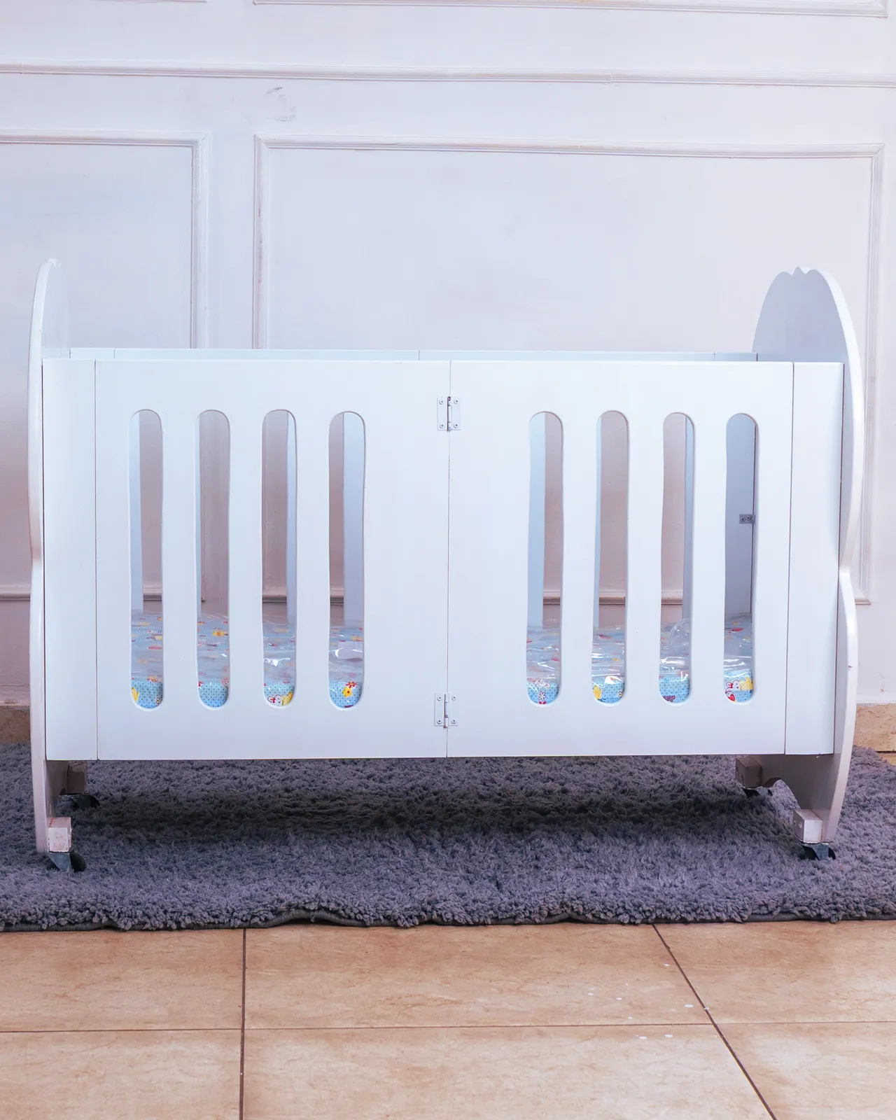 Foldable Baby Cot With Mattress 3 Front View Of White Wooden Foldable Baby Cot With Mattress Included, Available At Zawadi Baby Shop Ibea Building.