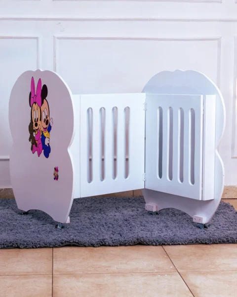 Side profile of white baby cot featuring adorable Mickey Mouse character decal on the headboard.
