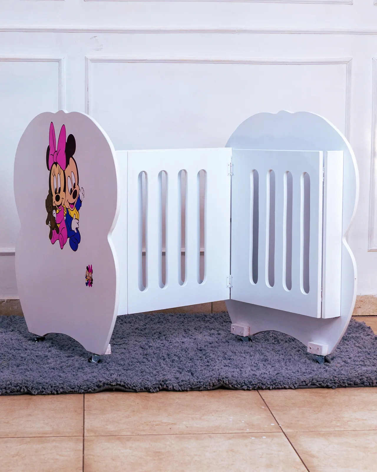 Foldable Baby Cot With Mattress 1 Side Profile Of White Baby Cot Featuring Adorable Mickey Mouse Character Decal On The Headboard.