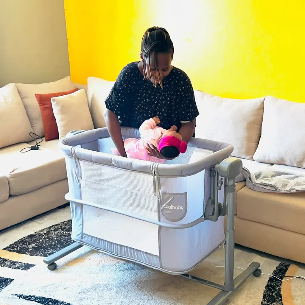 Coolbaby 2 In 1 Electric Bassinet 3 Mum Laying Her Baby In The 2 In 1 Electric Bassinet, At Zawadi Baby Shop Nairobi.